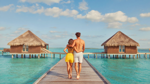 Couple walking toward an overwater villa in the Maldives